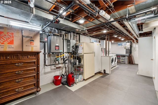 below grade area featuring tankless water heater, washer and dryer, and freestanding refrigerator