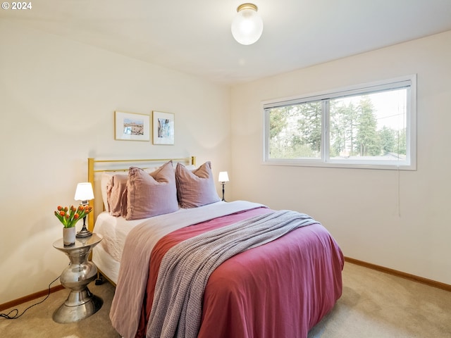 bedroom featuring light colored carpet and baseboards