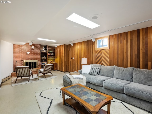 living area with a fireplace, light floors, a baseboard radiator, wooden walls, and track lighting