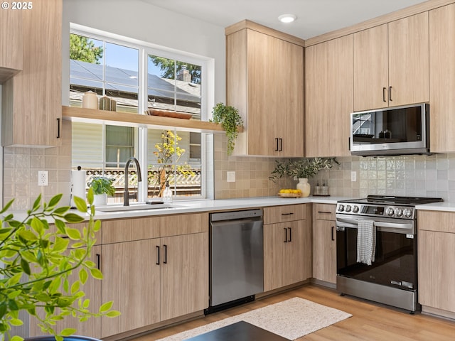 1562 NE 52nd Ave, Portland, OR 97213 - kitchen featuring appliances with stainless steel finishes, a sink, light brown cabinetry, light countertops, and recessed lighting