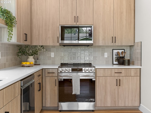 1562 NE 52nd Ave, Portland, OR 97213 - kitchen with appliances with stainless steel finishes, light brown cabinets, light countertops, decorative backsplash, and modern cabinets