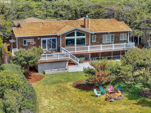 4580 Fairway Ave, Gearhart, OR 97138 - back of house featuring an outdoor fire pit, a deck, a yard, a chimney, and a patio