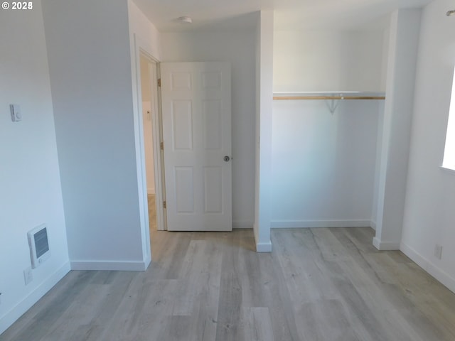 unfurnished bedroom with a closet and light hardwood / wood-style flooring