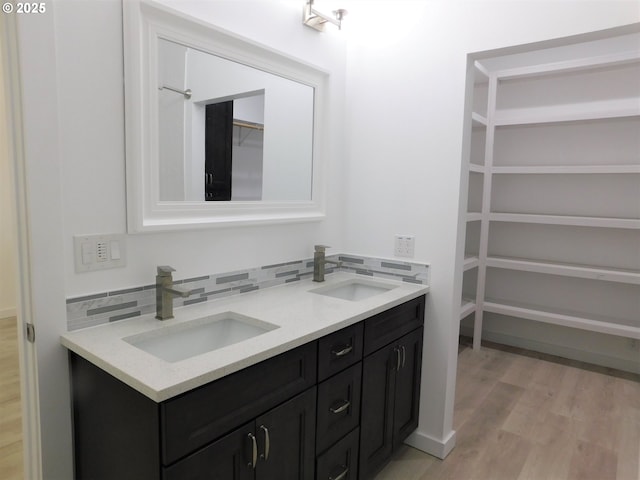 bathroom with tasteful backsplash, wood-type flooring, and vanity