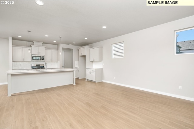 8909 S 3rd St Unit 30, Ridgefield, WA 98642 - kitchen featuring appliances with stainless steel finishes, baseboards, recessed lighting, light wood-style floors, and light countertops