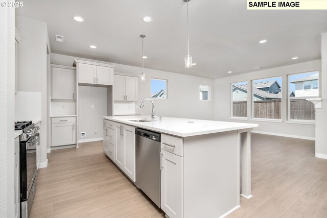 8909 S 3rd St Unit 30, Ridgefield, WA 98642 - kitchen featuring stainless steel dishwasher, a sink, gas range, light wood-style flooring, and a center island with sink