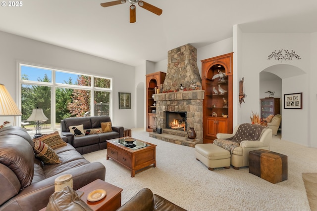 558 Wulff Ln, Roseburg, OR 97471 - living area with carpet floors, arched walkways, ceiling fan, and a stone fireplace