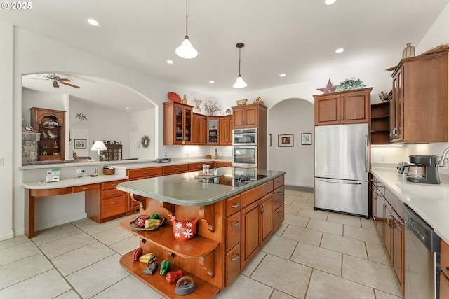558 Wulff Ln, Roseburg, OR 97471 - kitchen with appliances with stainless steel finishes, open shelves, arched walkways, brown cabinets, and light tile patterned flooring