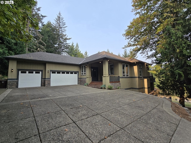 prairie-style house featuring concrete driveway, a garage, stone siding, and a shingled roof