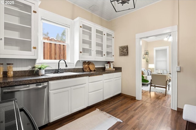 kitchen featuring white cabinets, dark wood-type flooring, an inviting chandelier, sink, and stainless steel dishwasher