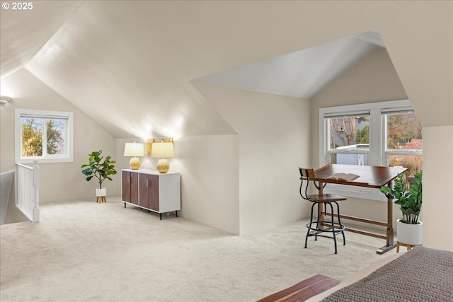 interior space with light carpet and vaulted ceiling