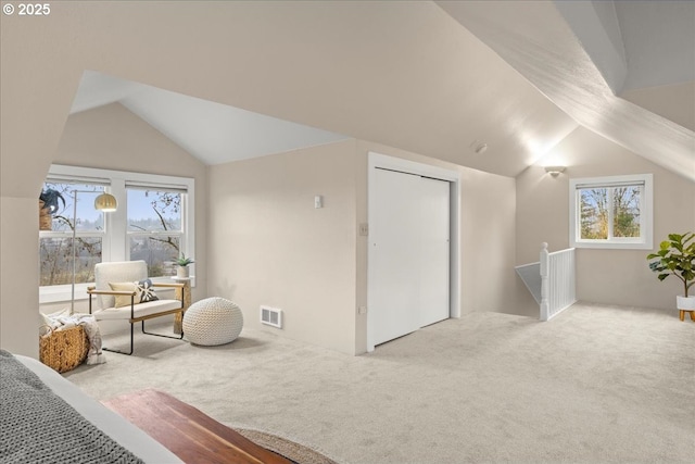 bonus room with vaulted ceiling, light carpet, and a healthy amount of sunlight