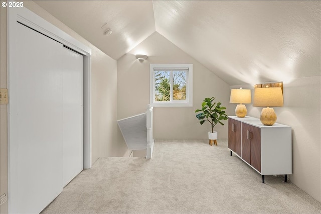 bonus room with light carpet and lofted ceiling