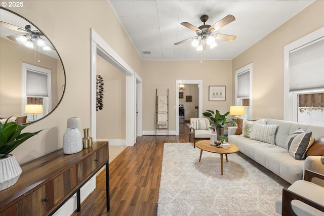 living room featuring dark wood-type flooring and ceiling fan