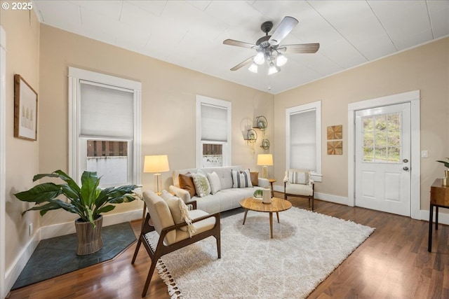 living room featuring ceiling fan and dark hardwood / wood-style floors