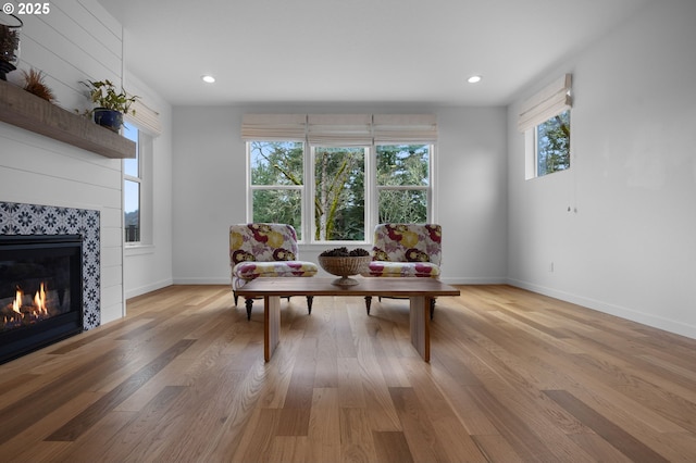 sitting room with recessed lighting, light wood-style floors, baseboards, and a tile fireplace