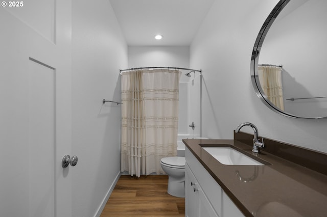 bathroom with baseboards, toilet, wood finished floors, shower / bath combination with curtain, and vanity