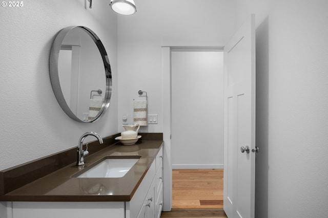 bathroom featuring baseboards, wood finished floors, and vanity