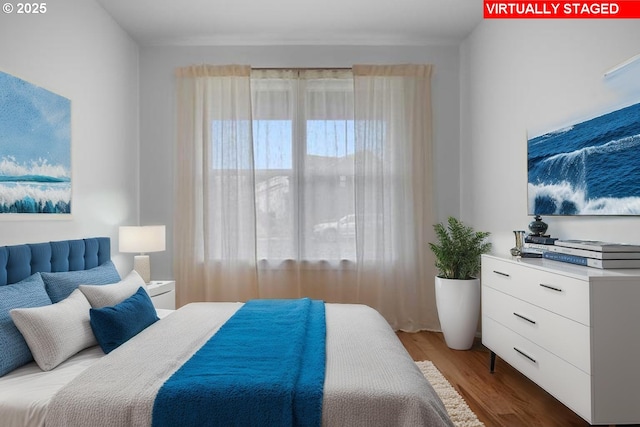 bedroom with multiple windows and wood finished floors