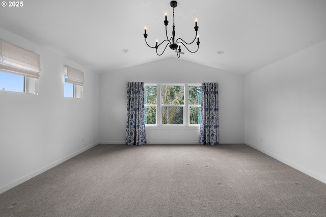 carpeted spare room with baseboards, lofted ceiling, and a chandelier