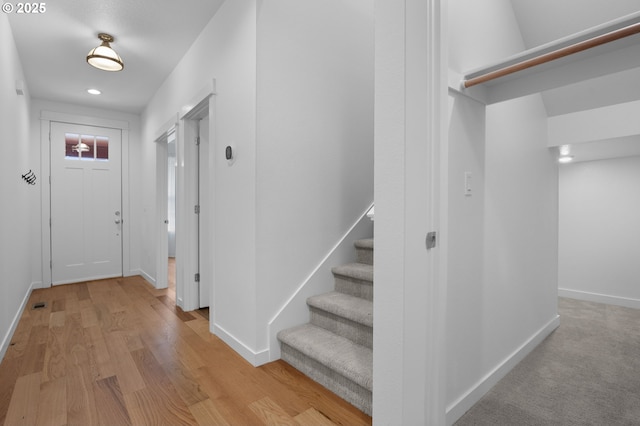 entrance foyer featuring baseboards, stairway, light wood finished floors, and recessed lighting