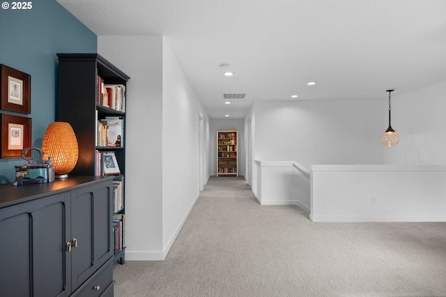 hallway featuring light carpet, an upstairs landing, baseboards, and recessed lighting