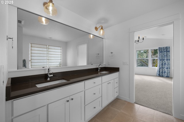 bathroom featuring a sink, visible vents, double vanity, and tile patterned floors