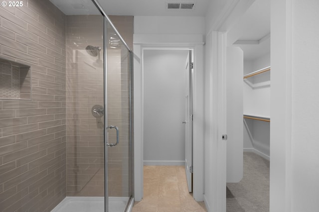 full bathroom with a shower stall, a spacious closet, and baseboards