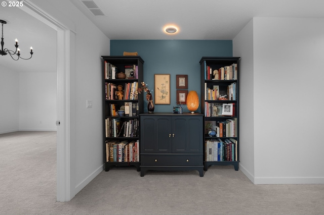 interior space with baseboards, light carpet, an inviting chandelier, and visible vents