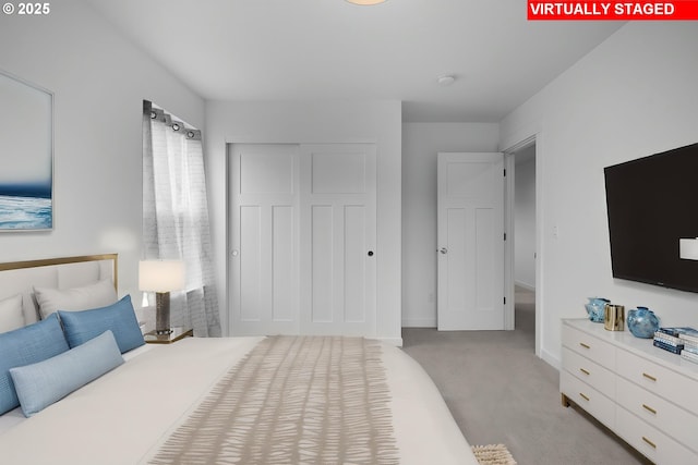 bedroom featuring baseboards, light carpet, and a closet