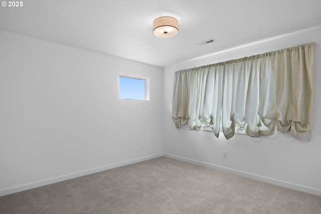 unfurnished room featuring baseboards, visible vents, and carpet floors