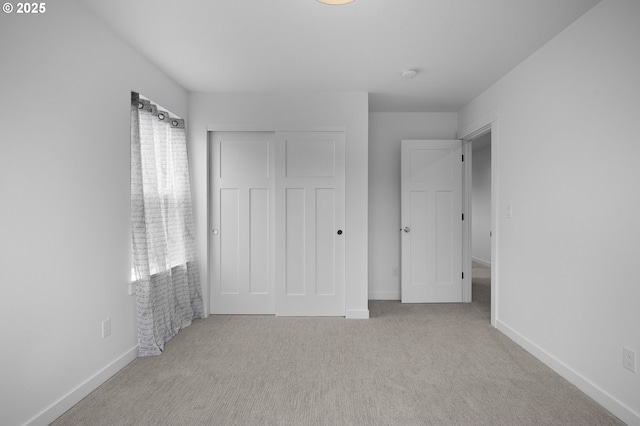 unfurnished bedroom with a closet, baseboards, and carpet