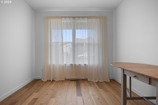 empty room with visible vents, wood finished floors, and baseboards