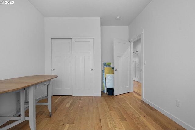 home office with baseboards and light wood-style flooring