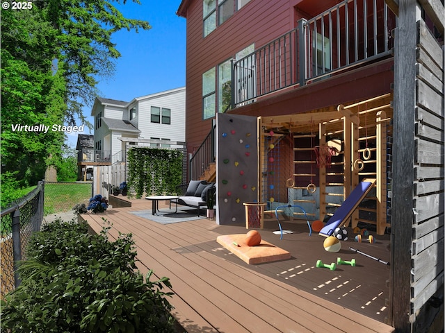 wooden terrace featuring fence and stairs