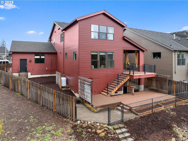 rear view of property with a gate, a patio, a fenced backyard, a shingled roof, and stairs