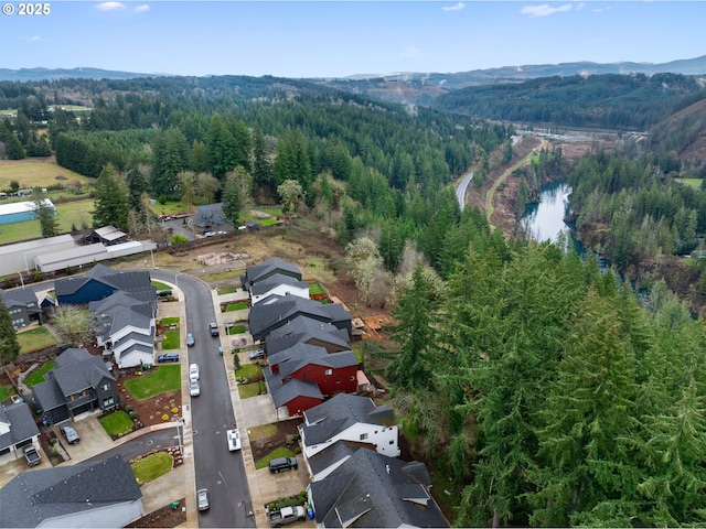 birds eye view of property featuring a view of trees, a residential view, and a water and mountain view