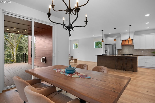 dining space with light wood finished floors, a chandelier, and recessed lighting