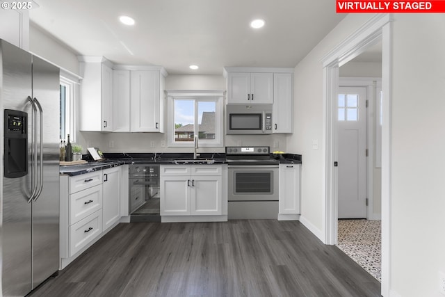 502 Williams Ave, Tillamook, OR 97141 - kitchen with appliances with stainless steel finishes, a sink, dark countertops, white cabinetry, and healthy amount of natural light