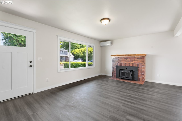 502 Williams Ave, Tillamook, OR 97141 - unfurnished living room featuring a wall mounted AC, wood finished floors, baseboards, and a wood stove