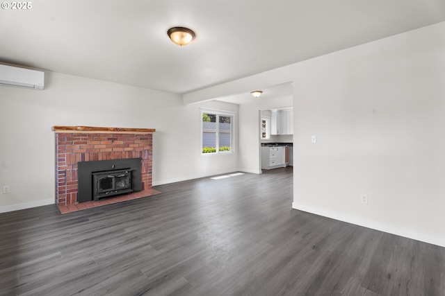 502 Williams Ave, Tillamook, OR 97141 - unfurnished living room with dark wood-type flooring, baseboards, a wall mounted AC, and a wood stove