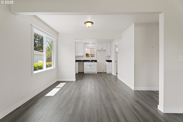 502 Williams Ave, Tillamook, OR 97141 - unfurnished living room with dark wood finished floors, baseboards, and a sink
