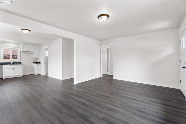 502 Williams Ave, Tillamook, OR 97141 - unfurnished living room with a sink, dark wood-style floors, and baseboards