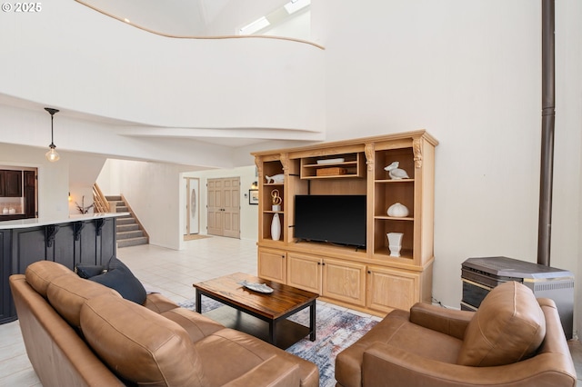 living room with stairway, light tile patterned flooring, and a towering ceiling