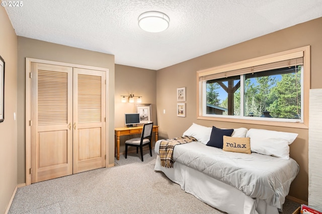 bedroom featuring a textured ceiling, a closet, and light carpet