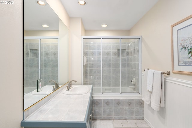 bathroom with tile patterned flooring, recessed lighting, vanity, and tiled shower / bath