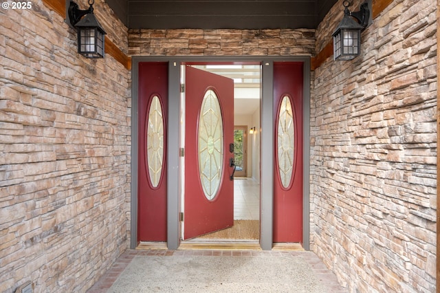 entrance to property featuring stone siding and brick siding