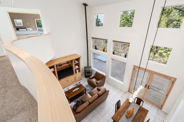 living area featuring a wood stove and a towering ceiling