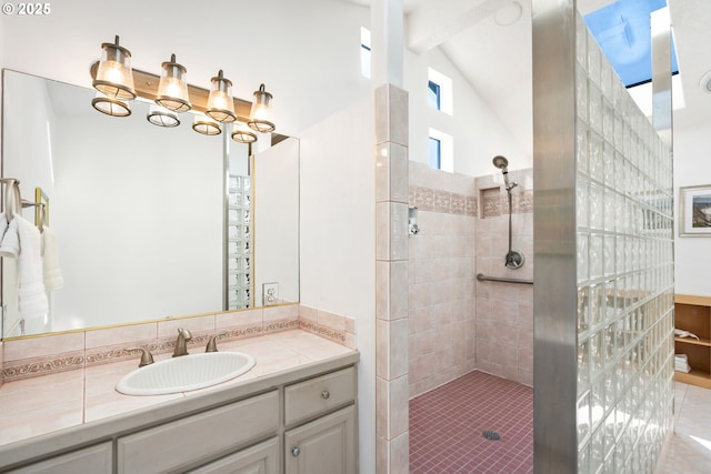 full bath with lofted ceiling with beams, vanity, and a tile shower