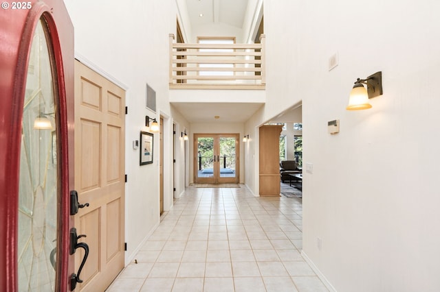 entryway featuring light tile patterned floors, visible vents, baseboards, french doors, and a towering ceiling